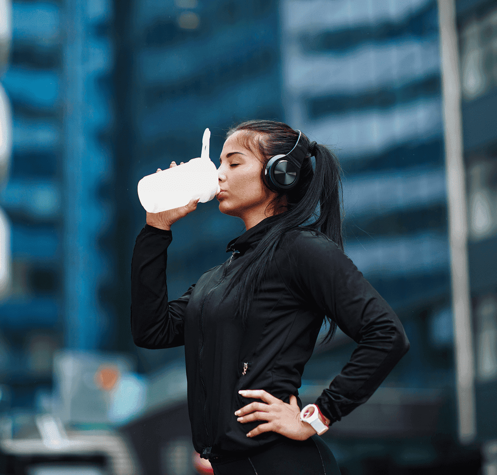Woman in black sportswear drinking from a bottle